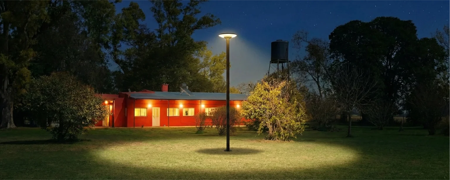 Casa de noche iluminada con un farol solar y un tanque de agua